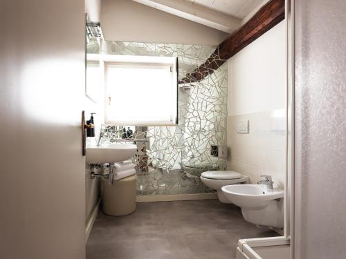 a bathroom with a sink and a toilet and a mirror at SOUL OF TRENTO Exclusive Jacuzzi Loft in Trento