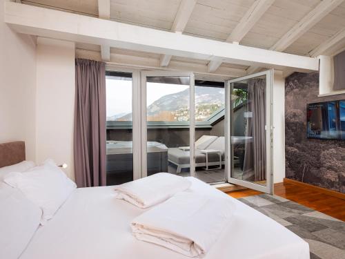 a bedroom with a white bed and a balcony at SOUL OF TRENTO Exclusive Jacuzzi Loft in Trento