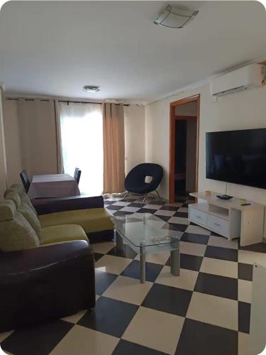 a living room with a couch and a tv at Piso Delfin Playa in Moncófar