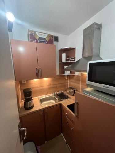 a small kitchen with a sink and a microwave at Appartement pied ESF in La Toussuire