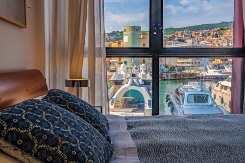a bedroom with a window with a view of a harbor at APPARTAMENTO SUL MARE KATE in Genoa
