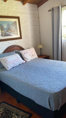 a bedroom with a bed with a blue comforter at Armonía in Villa Serrana