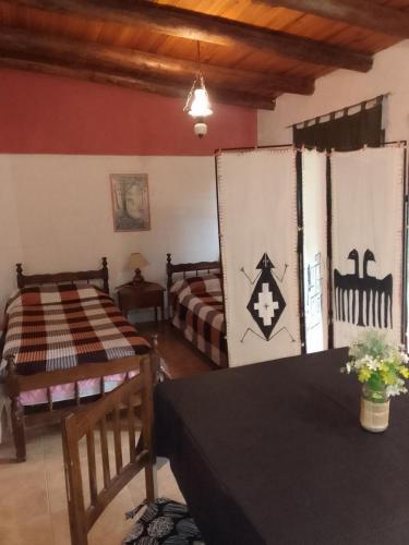 a room with two beds and a table at El Espinillo 2 in La Falda
