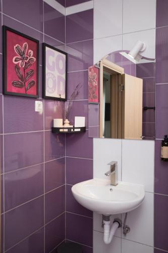 a purple bathroom with a sink and a mirror at Mostay Boutique Hotel in Mostar