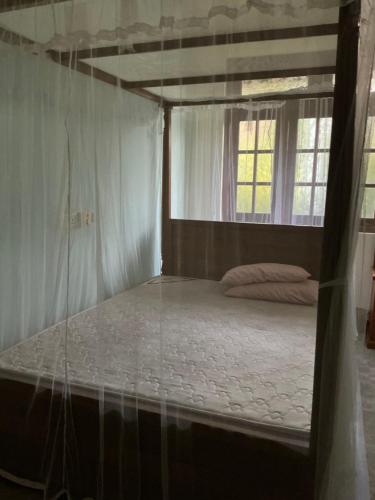 a bed in a room with a window at Villa Sadalla in Hikkaduwa
