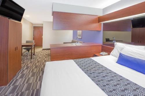 a hotel room with a bed and a desk at Microtel Inn and Suites Manistee in Manistee