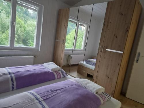 two beds in a room with two windows at Apartments Rainbow in Pörtschach am Wörthersee