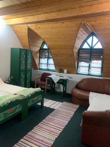 a room with two beds and a couch and a table at Góbé Csárda in Oradea
