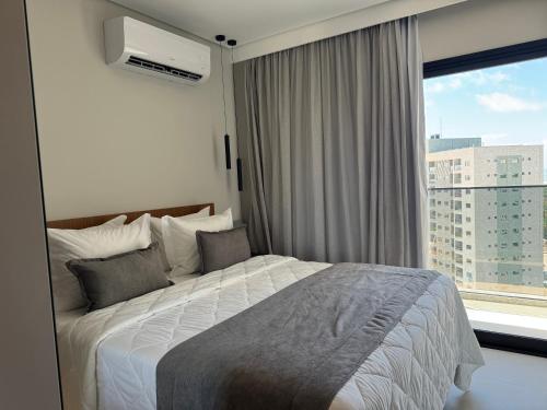 a bedroom with a bed and a large window at Salinas Beach Resort in Salinópolis