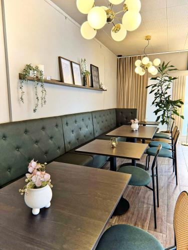 a restaurant with two tables and chairs and lights at Hotel Amadeus Halmstad in Halmstad
