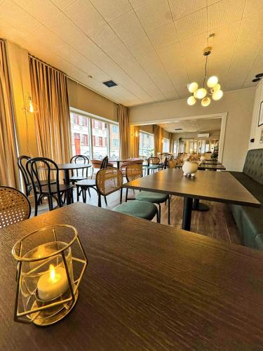 a dining room with tables and chairs and tablesktop at Hotel Amadeus Halmstad in Halmstad