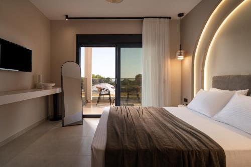 a bedroom with a bed and a balcony at Pnoe Boutique suites in Nikiti