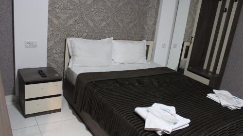 a bedroom with a bed with two towels on it at Lux hotel in Tbilisi City