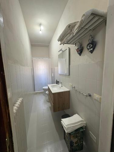 a white bathroom with a sink and a toilet at Dimora Corso Roma in Montecatini Terme