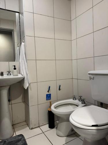 a white bathroom with a toilet and a sink at Danella in San Miguel de Tucumán