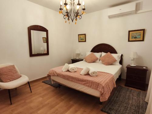 a bedroom with a bed and a chair and a mirror at Apartamento El Rinconcito de Martina in Jarandilla de la Vera