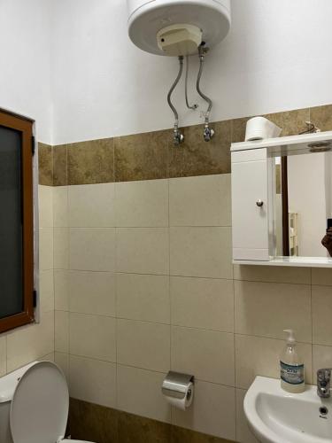a bathroom with a toilet and a sink and a mirror at Zefi Grill House in Lezhë