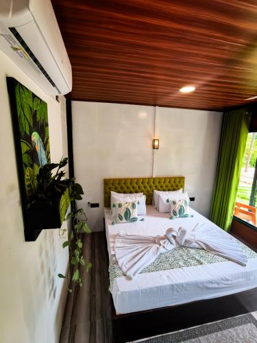 a bedroom with a bed with a wooden ceiling at Rhythm Beach in Trincomalee