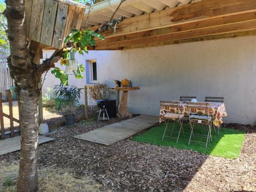 a patio with a table and chairs under a building at Maisonnette cosy au calme avec jardin clos - Puy dufou in La Ronde