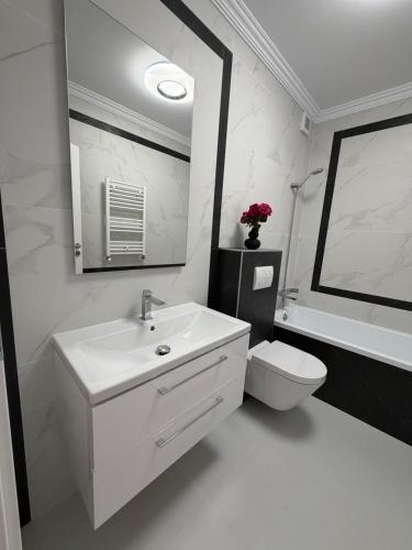 a white bathroom with a sink and a toilet at Best Luxury Residence in Bistriţa