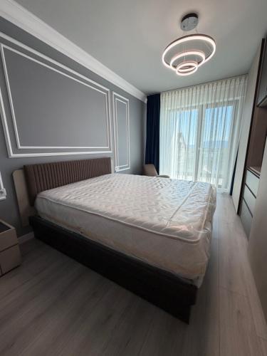 a bedroom with a bed and a large window at Best Luxury Residence in Bistriţa