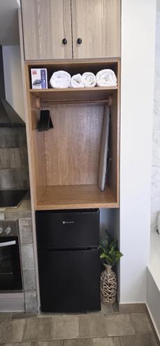a kitchen with a cupboard with plates and towels at Blue horizon apartment & suite in Kalymnos