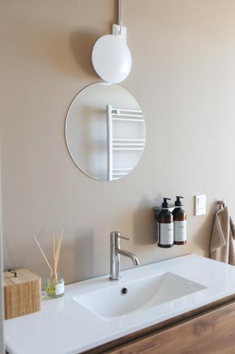 a bathroom with a sink and a mirror at Albi's Sandvig Boutique Hotel in Sandvig