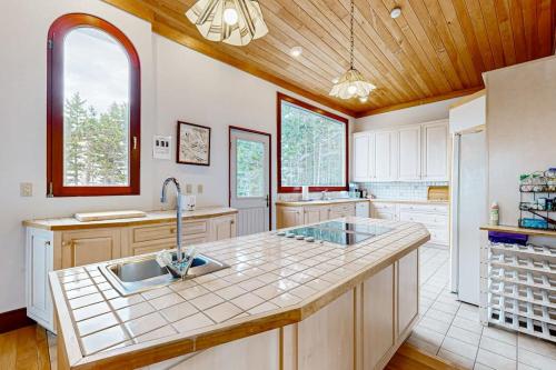 a large kitchen with a sink and a refrigerator at Private Oceanfront Home -- 2 Fireplaces, 4 Decks & Grill, Dog-friendly in East Boothbay
