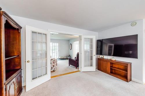 a living room with a large flat screen tv at Idyllic waterfront home with furnished deck, grill, sweeping views & private W/D in Waldoboro