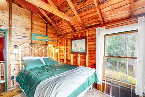 a bedroom with a bed in a log cabin at Cozy, Waterfront Cabin-Style Gem with Private Dock and Lovely Views in East Harpswell