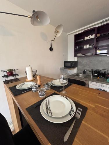 a kitchen with a table with plates and forks and napkins at La nuit calme in Annemasse