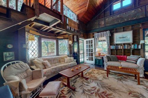 a living room with a couch and a table at Spacious Waterfront Estate & Cabins W/ Porch, Fireplace, Kayaks & Free WiFi in Brunswick