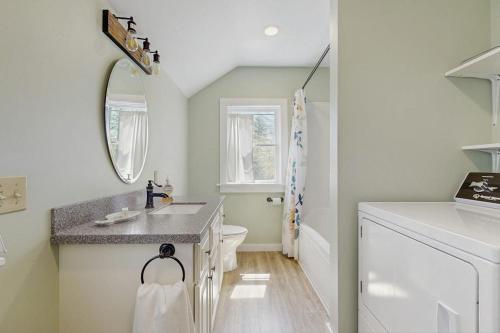 a bathroom with a sink and a toilet at Modern farmhouse with deck, firepit, & balcony in Northport