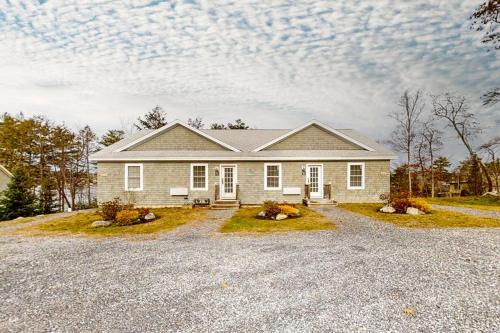 a house with a gravel driveway in front of it at Water-view condo at Sheepscot Harbour Resort with deck, full kitchen, and WiFi in Edgecomb