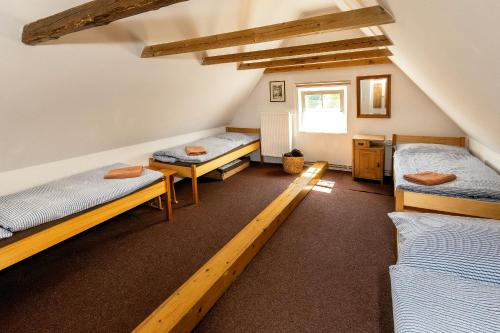 a room with three beds and a window at Apartmány Havana in Český Krumlov