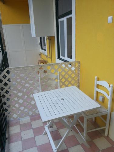 a white picnic table and a chair on a balcony at Residência Almirante in Lisbon