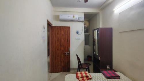 a room with a table and a wooden door at Radhe Krishna Guest House in Srīrangam