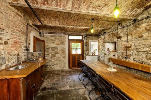 a kitchen with a long counter and a stone wall at Apartmány Havana in Český Krumlov