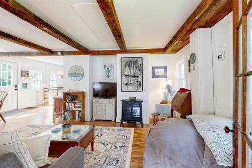 a living room with a couch and a table at Charming Boothbay Harbor cottage with partial AC, full kitchen, and sun room in Boothbay Harbor