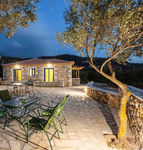 a patio with a table and chairs and a tree at MANI HOLIDAY HOUSE in Kotrónion
