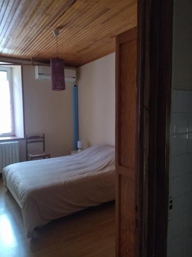 a bedroom with a bed with a wooden ceiling at Les sources de la Loire 2 in Sainte-Eulalie