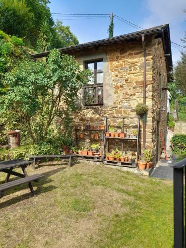 a stone cottage with a picnic table in front of it at Vega in Muñás