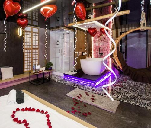 a room with a bath tub and red heart balloons at Grey Champagne Spa by Secret Apartament in Gdańsk