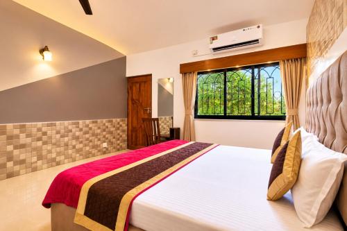 a bedroom with a bed and a window at Shiva Apartments & Stud!os GOA in Parra