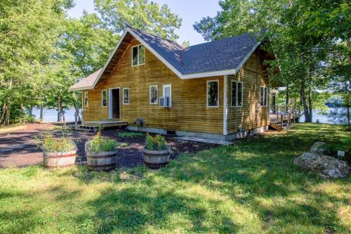 a small house with potted plants in front of it at Private waterfront home with large deck & deep water dock in Georgetown