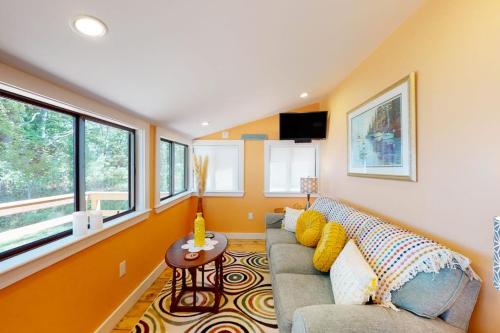 a living room with a couch and a table at Waterfront home on St George River with private beach & deck - near festivals in Cushing
