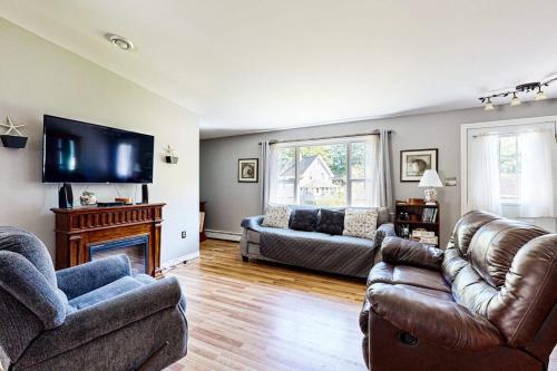 a living room with two couches and a tv at Charming cottage near the beach with balcony, deck, grill, fireplace - dogs OK in Georgetown