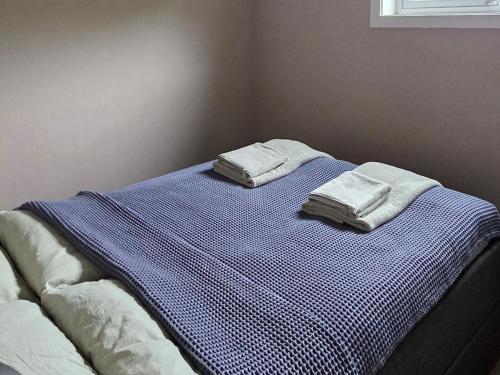 a bed with two towels on top of it at Fjordside Apartment in Åndalsnes