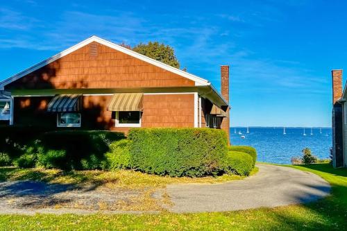a house with a driveway in front of the water at Waterfront home with beautiful bay views - near shops & dining in Owls Head