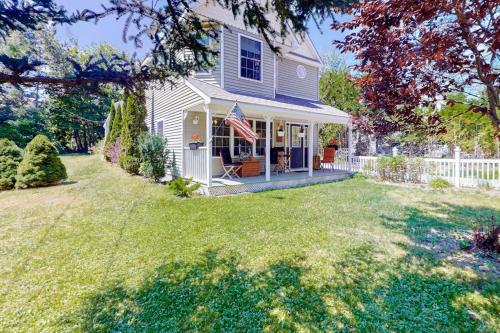 a house with an american flag in the yard at Two-story home steps from Laite Beach - stroll to the harbor, 1 dog welcome in Camden